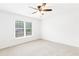 Neutral bedroom featuring a ceiling fan, plush carpet, and natural light from a large window at 1342 Winborn Nw Cir, Kennesaw, GA 30152