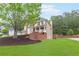 Beautiful brick home with covered porch, lush lawn, and mature trees at 1342 Winborn Nw Cir, Kennesaw, GA 30152