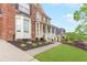Well-manicured lawn and landscaping with view of the covered porch and brick home at 1342 Winborn Nw Cir, Kennesaw, GA 30152