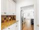 Open kitchen with white cabinets, granite counters, and stainless steel appliances leading to breakfast nook at 1342 Winborn Nw Cir, Kennesaw, GA 30152