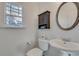 Powder room with pedestal sink, round mirror, and natural light from the window at 1365 Memorial Se Dr # 8, Atlanta, GA 30317
