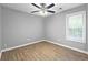 Bright bedroom featuring wood-look flooring, ceiling fan, and natural light from the window at 2727 Northgate Nw Way, Acworth, GA 30101