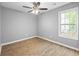 Bright bedroom featuring wood-look flooring, ceiling fan, and natural light from the window at 2727 Northgate Nw Way, Acworth, GA 30101