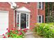 Elegant front door with decorative trim, framed by colorful landscaping and brick facade at 2727 Northgate Nw Way, Acworth, GA 30101