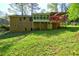 Lush backyard showcasing a home with sunroom addition and spacious deck, perfect for entertaining at 3341 Rae Pl, Lawrenceville, GA 30044