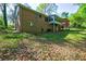 View of brick house with a sunroom addition, a wooden deck, and a grassy backyard at 3341 Rae Pl, Lawrenceville, GA 30044