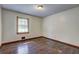 Simple bedroom featuring hardwood floors and natural light from a single window at 3341 Rae Pl, Lawrenceville, GA 30044