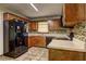 Cozy kitchen with wooden cabinetry, tiled backsplash, and modern black appliances at 3341 Rae Pl, Lawrenceville, GA 30044