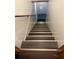 Modern staircase with dark wood steps and metal trim, leading to a lower level at 3341 Rae Pl, Lawrenceville, GA 30044