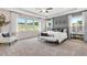 Spacious bedroom with large windows, tray ceiling, and a seating area with natural light at 5335 Trescott Path, Cumming, GA 30028