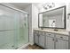 Modern bathroom with glass shower door, and granite countertop with dual sinks at 7492 Knoll Hollow Rd, Lithonia, GA 30058