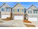 Charming townhouse with brick accents, white garage door, and well-maintained landscaping on a sunny day at 7492 Knoll Hollow Rd, Lithonia, GA 30058