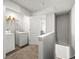 Well-lit laundry area with washer, dryer, and shelving for storage at 7492 Knoll Hollow Rd, Lithonia, GA 30058