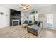 Cozy living room with a fireplace, comfortable seating, a ceiling fan, and abundant natural light at 7492 Knoll Hollow Rd, Lithonia, GA 30058