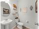 Chic powder room with a pedestal sink, stylish decor, and wood-look flooring at 7492 Knoll Hollow Rd, Lithonia, GA 30058