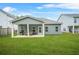 A backyard features a covered patio, a green lawn, and a house with blue siding at 9010 Jim Purcell Dr, Covington, GA 30014