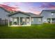 A backyard features a covered patio, a green lawn, and a house with blue siding at 9010 Jim Purcell Dr, Covington, GA 30014