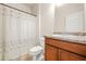 Functional bathroom with a toilet, vanity, and shower with patterned shower curtain at 9010 Jim Purcell Dr, Covington, GA 30014