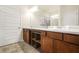 Bathroom features dual sinks with dark wood cabinets and granite countertops, with a large mirror and updated fixtures at 9010 Jim Purcell Dr, Covington, GA 30014