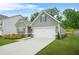 Well-maintained one-story home with a two-car garage and manicured lawn, set against a backdrop of lush trees at 9010 Jim Purcell Dr, Covington, GA 30014