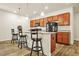 Cozy eat-in kitchen with wooden cabinets, granite countertops, and bar stool seating at the breakfast bar at 9010 Jim Purcell Dr, Covington, GA 30014