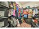 A walk-in closet is full of assorted items in storage containers and hanging on a rod at 9010 Jim Purcell Dr, Covington, GA 30014