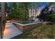 Backyard retreat featuring a stone-lined pool, lush landscaping, and a storage shed nestled amongst mature trees at 2040 Parliament Dr, Lawrenceville, GA 30043