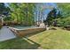 Scenic backyard with a pool, spa, manicured lawn, mature trees and storage shed at 2040 Parliament Dr, Lawrenceville, GA 30043