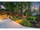 Serene backyard with a swing, lush greenery, and elegant lighting for evening enjoyment at 2040 Parliament Dr, Lawrenceville, GA 30043
