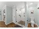 Modern tiled shower with glass door, stone floor, and black fixtures in the home's bathroom at 2040 Parliament Dr, Lawrenceville, GA 30043