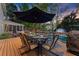 Outdoor dining area on a wooden deck with a large umbrella overlooking the backyard pool at 2040 Parliament Dr, Lawrenceville, GA 30043