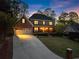 Beautiful two-story brick home with well-manicured lawn and welcoming front porch at dusk at 2040 Parliament Dr, Lawrenceville, GA 30043