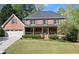 Charming two-story brick home with a welcoming front porch and manicured lawn at 2040 Parliament Dr, Lawrenceville, GA 30043