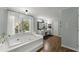 Relaxing main bathroom with soaking tub, dual sink vanity, and natural light streaming through a window at 2040 Parliament Dr, Lawrenceville, GA 30043