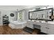 Large main bathroom with double vanity, soaking tub, wood look tile flooring, and lots of natural light at 2040 Parliament Dr, Lawrenceville, GA 30043