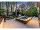 An inviting pool area with a stone-clad hot tub, surrounded by lush greenery, and a clear blue swimming pool at 2040 Parliament Dr, Lawrenceville, GA 30043