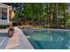Inviting pool area with stone accents, lush plants, and a tranquil waterfall feature for an outdoor living experience at 2040 Parliament Dr, Lawrenceville, GA 30043