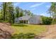 Rear view of the home with light gray siding surrounded by mature trees and a verdant lawn at 2841 Bettis Ct, Marietta, GA 30066