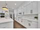 This modern kitchen features white cabinets, stainless steel appliances, and a center island with quartz countertops at 2841 Bettis Ct, Marietta, GA 30066