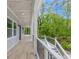 Wide covered porch with wood-look tile, white columns, and black railings offering a scenic view at 2841 Bettis Ct, Marietta, GA 30066
