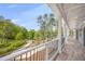 Expansive covered porch showcasing wood-look flooring, white columns, and a black metal railing with views at 2841 Bettis Ct, Marietta, GA 30066