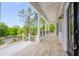 Spacious covered porch with wood-look tile flooring and black metal railing overlooking a wooded view at 2841 Bettis Ct, Marietta, GA 30066
