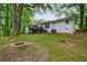 Expansive backyard features a brick fire pit, deck, and white brick house backdrop at 3803 Butternut Dr, Decatur, GA 30034