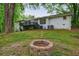 Large backyard with brick fire pit, white brick house, and a wooden deck at 3803 Butternut Dr, Decatur, GA 30034