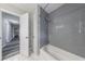 Bathroom with gray tiled shower/bath combo, white marble floors and access to hallway at 3803 Butternut Dr, Decatur, GA 30034