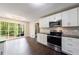 Modern kitchen featuring white cabinets, stainless steel appliances and a large window with green view at 3803 Butternut Dr, Decatur, GA 30034