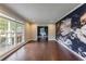 Bright living room with hardwood floors, a large window, and designer accent wall at 3803 Butternut Dr, Decatur, GA 30034