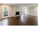 Open-concept living room with hardwood floors, a cozy fireplace, and a glass patio door at 3803 Butternut Dr, Decatur, GA 30034