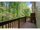 Private balcony with wooden railing overlooking lush green trees, offering a serene outdoor retreat at 404 Wade Creek Rd, Alpharetta, GA 30009