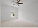 This bedroom has neutral carpet, white walls, and ceiling fan, and a large window at 404 Wade Creek Rd, Alpharetta, GA 30009